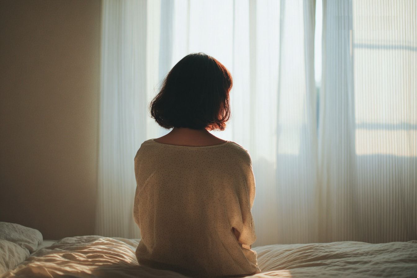 病院では異常がないと言われたのに、なんとなく不調が続いている雰囲気の後ろ姿の図