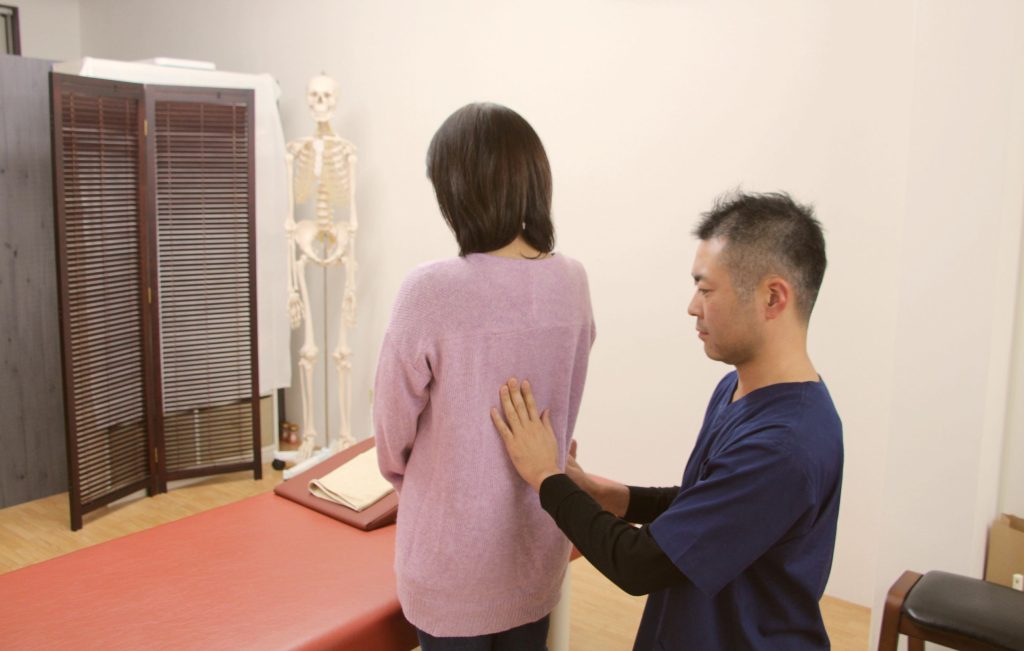 身体を確認している院長