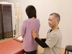 姿勢や身体の反応を確認している院長