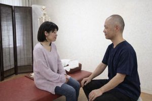 整体院福粋で来院者の話を聞く院長