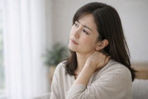 首を気にしている女性